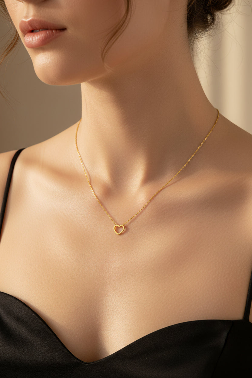 Eine Frau trägt eine Gold kette mit leichten Herzanhänger an ihrem dekoltee